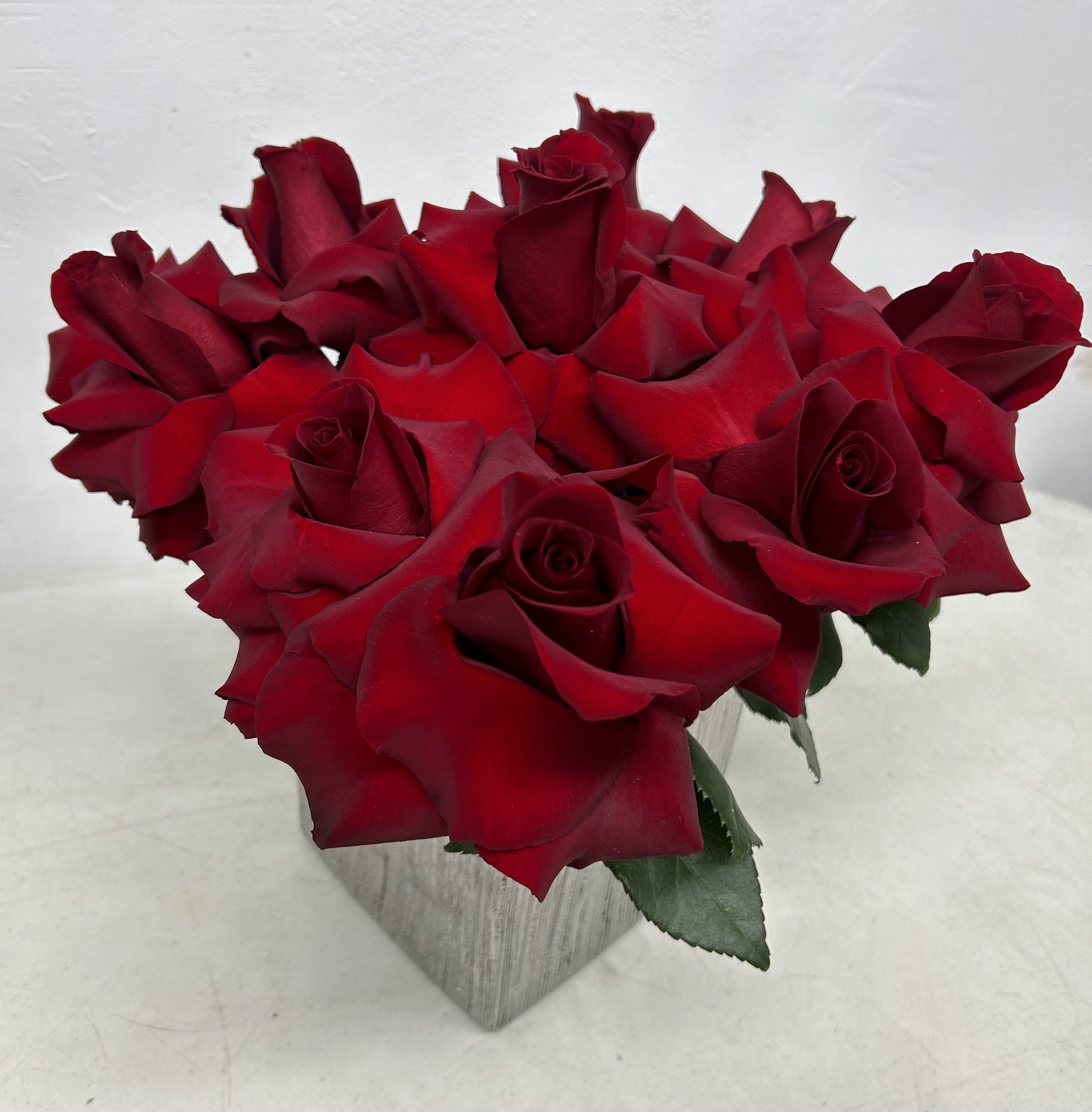 Bouquet of red roses in a square vase