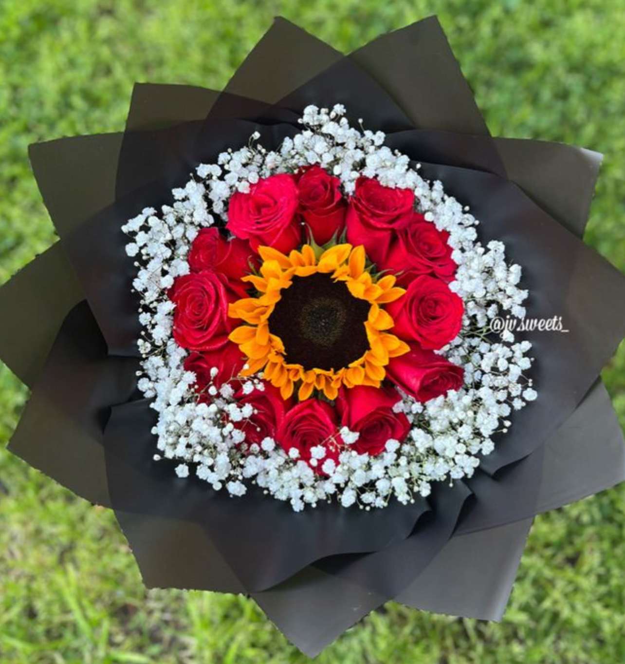 Bouquet of red roses with a sunflower center and white baby's breath