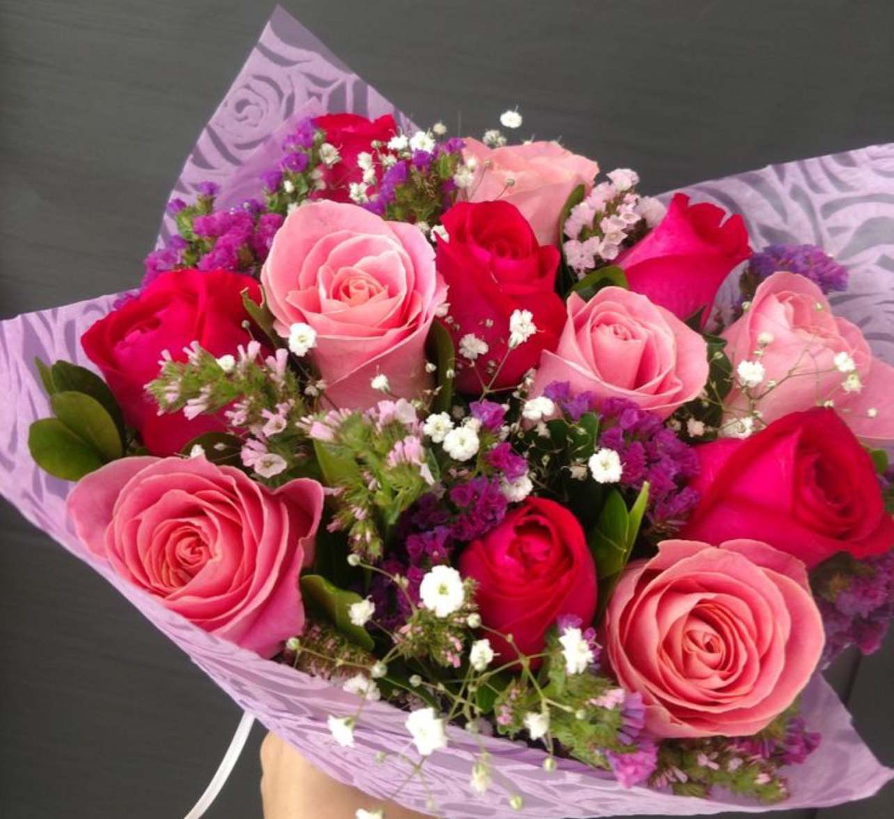 Bouquet of pink and red roses with purple filler flowers