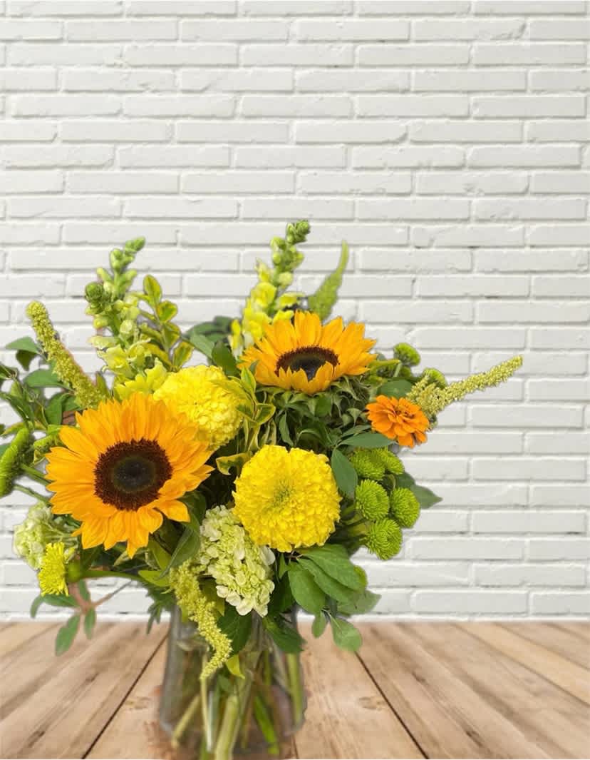 Sunflowers and yellow blooms in a glass vase