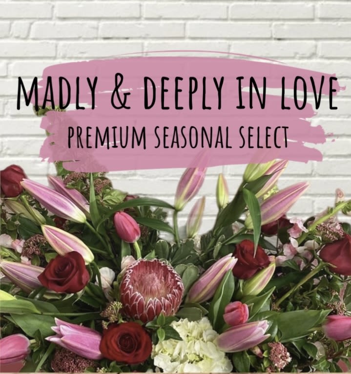 Bouquet of pink lilies, red roses, and a protea