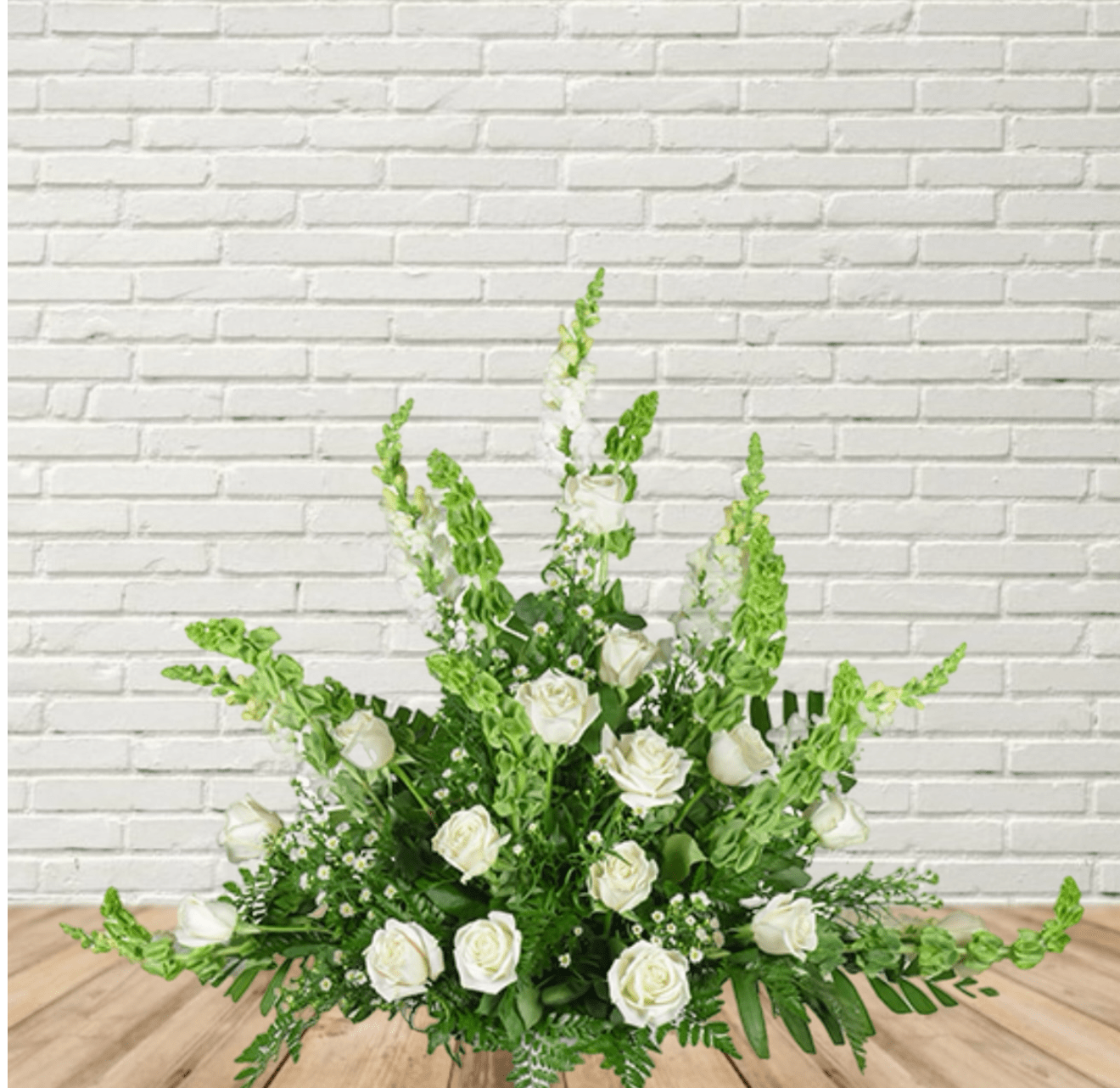 White rose arrangement with tall green spikes in a low design