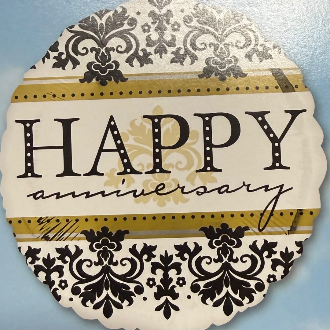 Decorative "Happy anniversary" sign with black floral patterns on a blue background