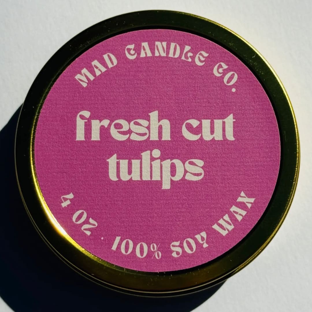 Round candle tin with a pink label reading fresh cut tulips