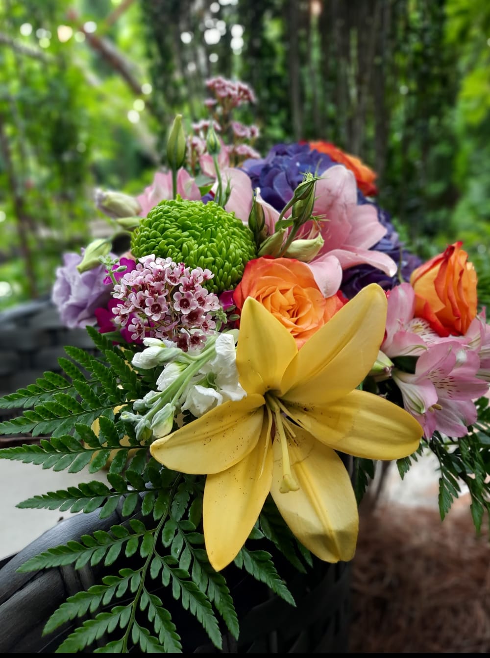 Colorful bouquet with yellow lily, orange roses, and pink blooms