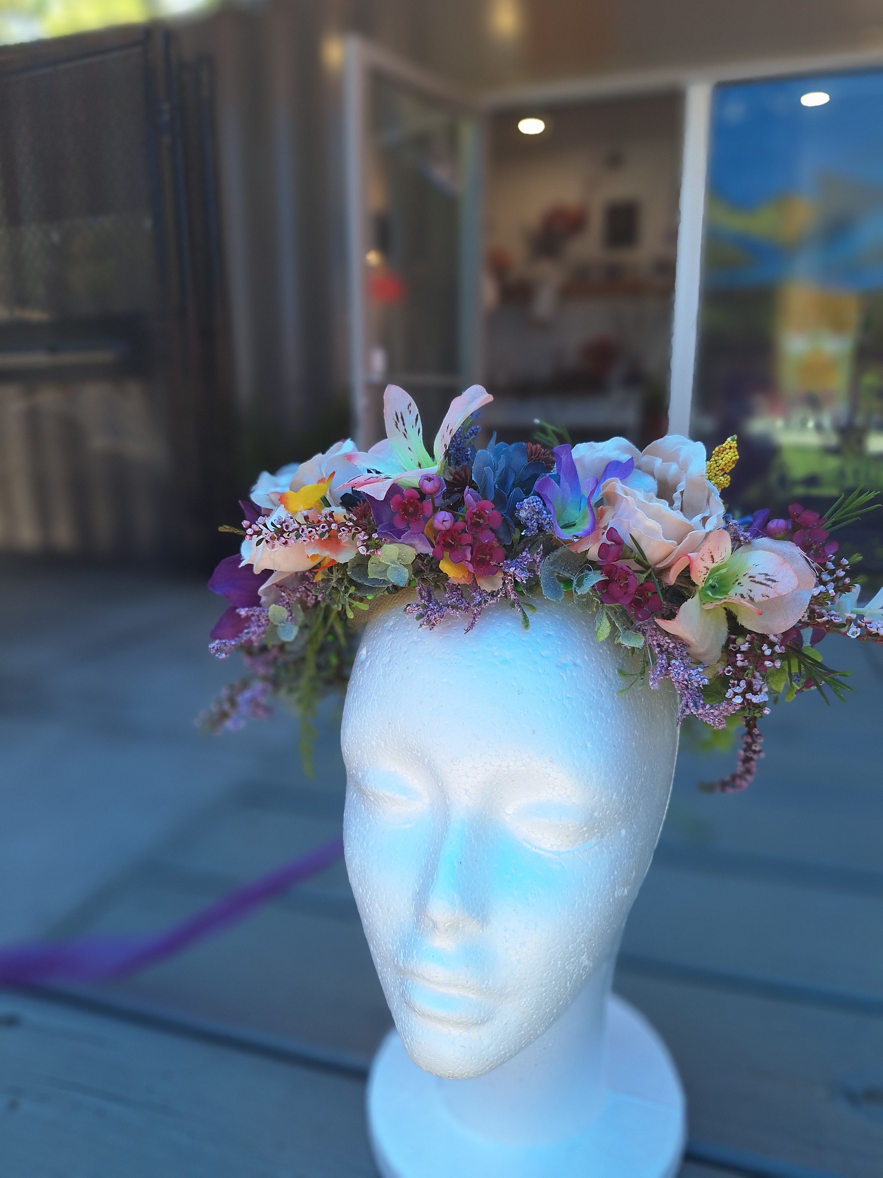 Floral crown with pastel flowers on a white mannequin head
