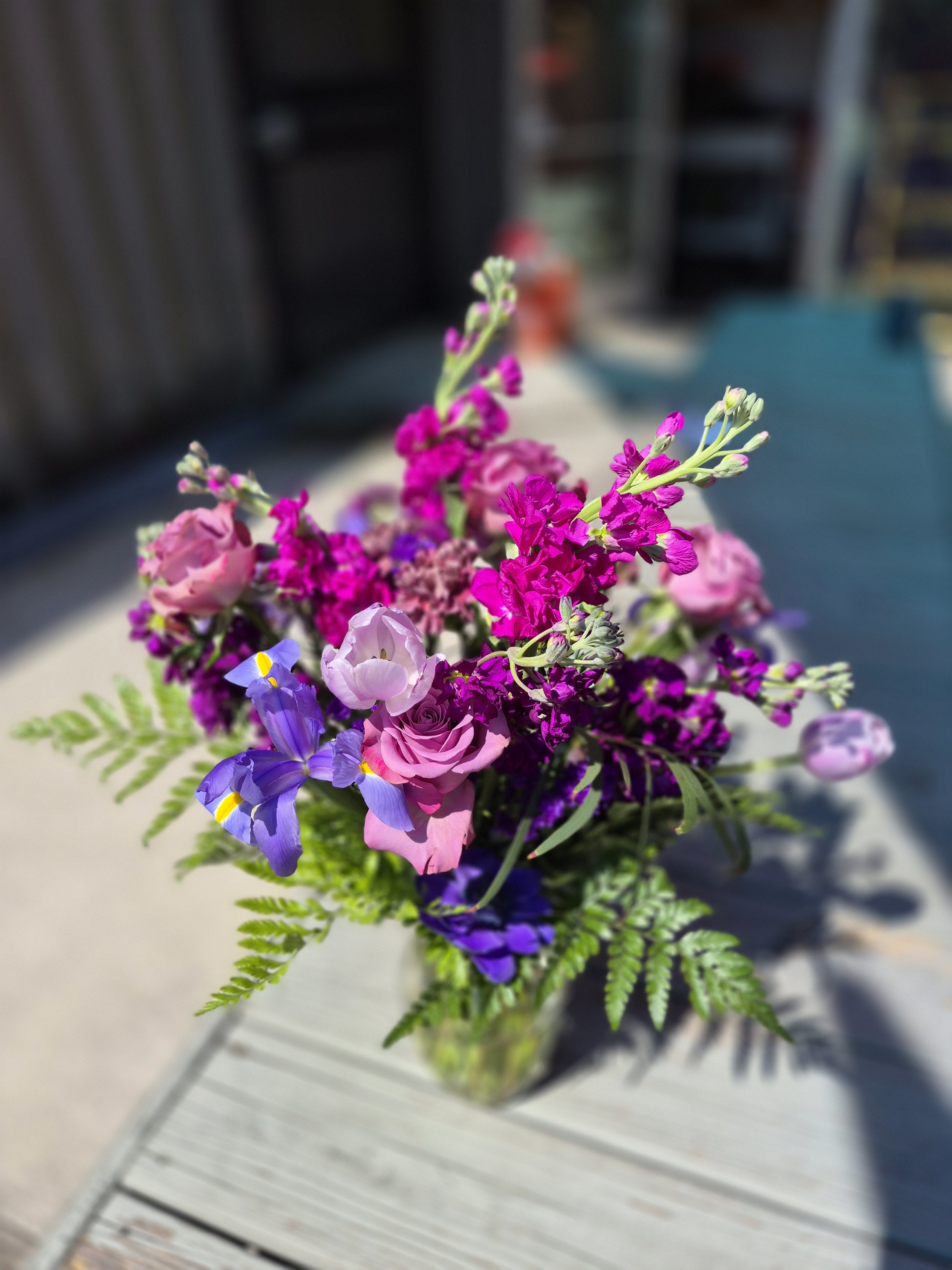 Nile Valley - An ode to the Phoenicians of Crete with an intoxicating arrangement of lavender Roses, Lisianthus, Alstroemeria, Iris, Carnations, spider Mums, Statice, Caspia and greenery in a clear vase. A Premium Bouquet is pictured.