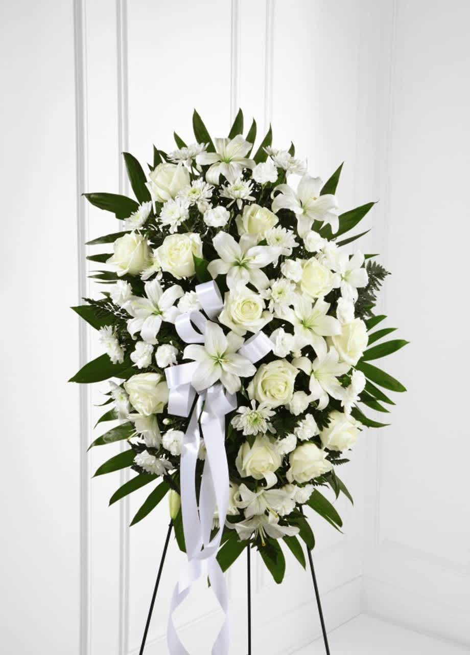 Tribute Standing Spray - Remind your loved ones that you are thinking of them during this time of sensitivity with a display of sweet serenity. Our Exquisite Tribute™ Standing Spray is elegantly crafted with roses, lilies, mini carnations and accented with palm fronds. Each bloom in this grand arrangement shares your thoughtful condolences. - Details