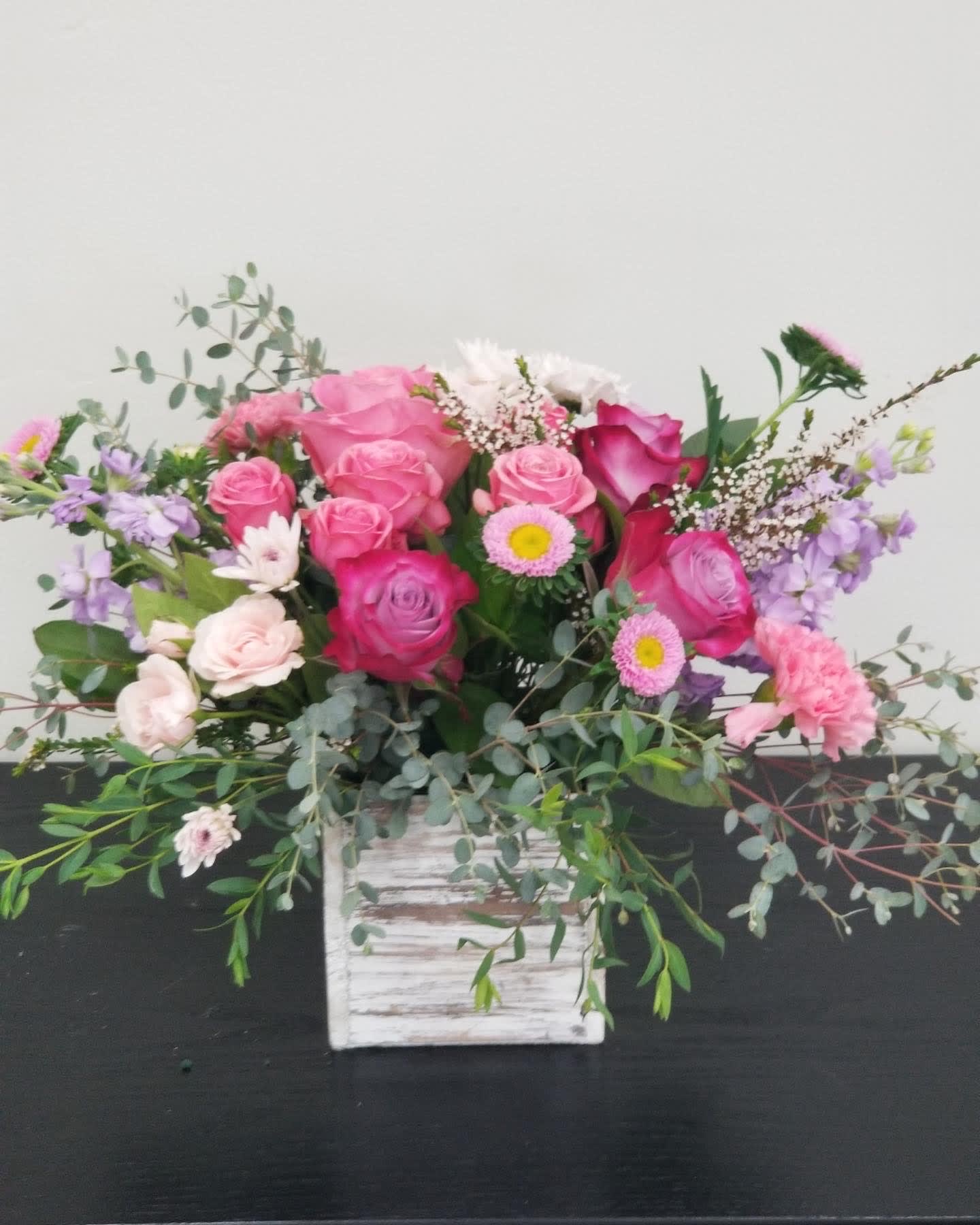 Pink and lavender rose bouquet in a white wooden box