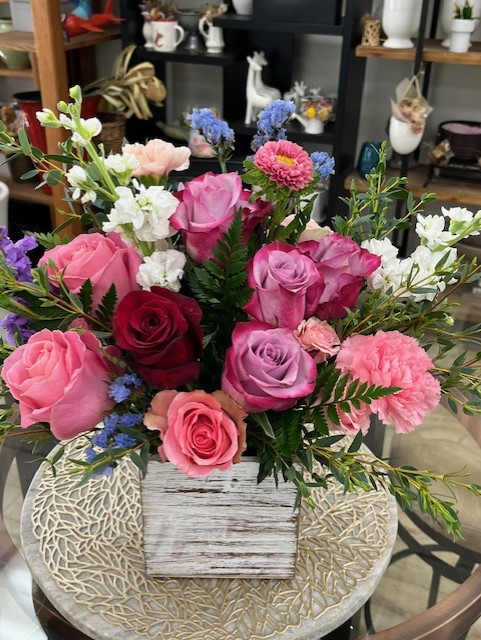 Mixed bouquet of pink and purple roses in a wooden box