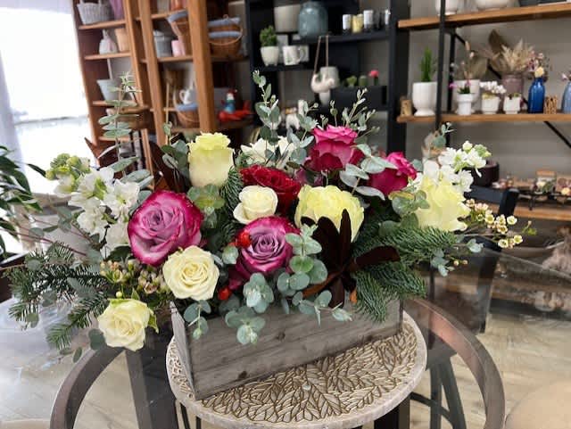 Mixed roses in a wooden box with eucalyptus and white filler flowers
