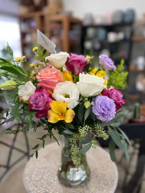Mixed bouquet of roses, lisianthus, and alstroemeria in a glass vase