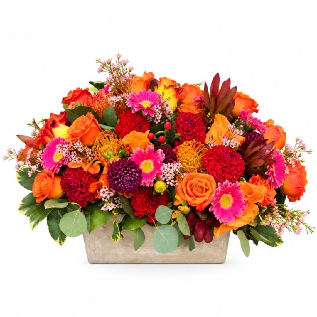 Bright mixed flower arrangement in a rectangular stone container