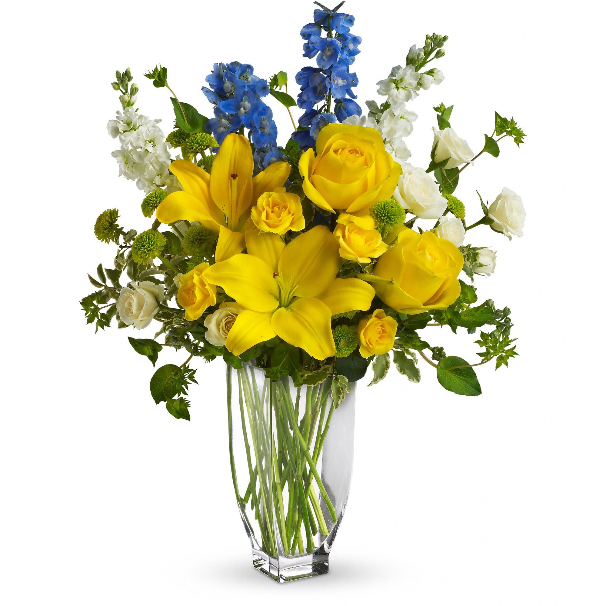 Tall yellow lilies and roses with blue delphinium and white blooms in a clear glass vase