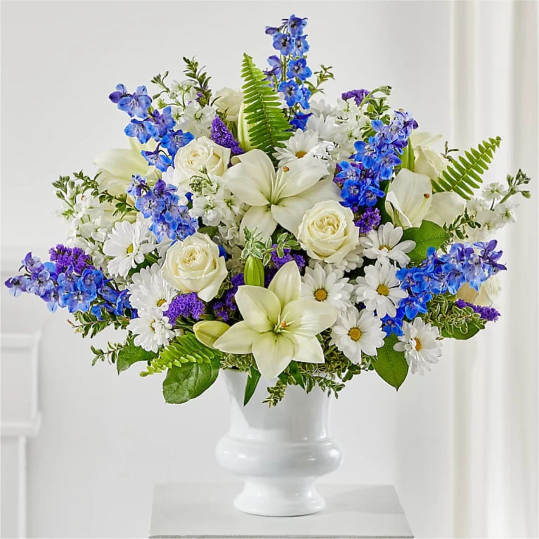 White and blue floral arrangement in a white vase