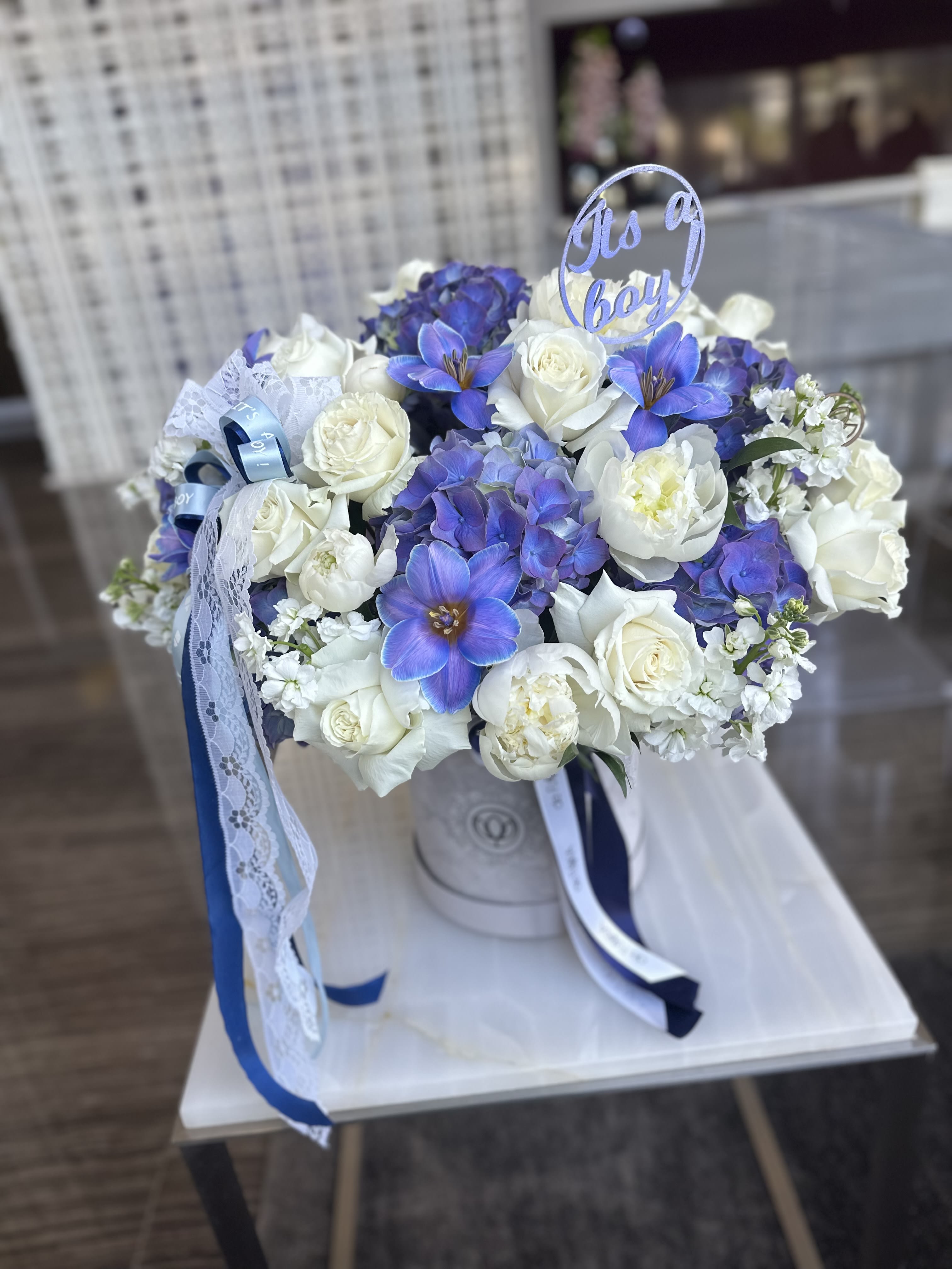 Blue and white bouquet with roses and orchids in a hatbox