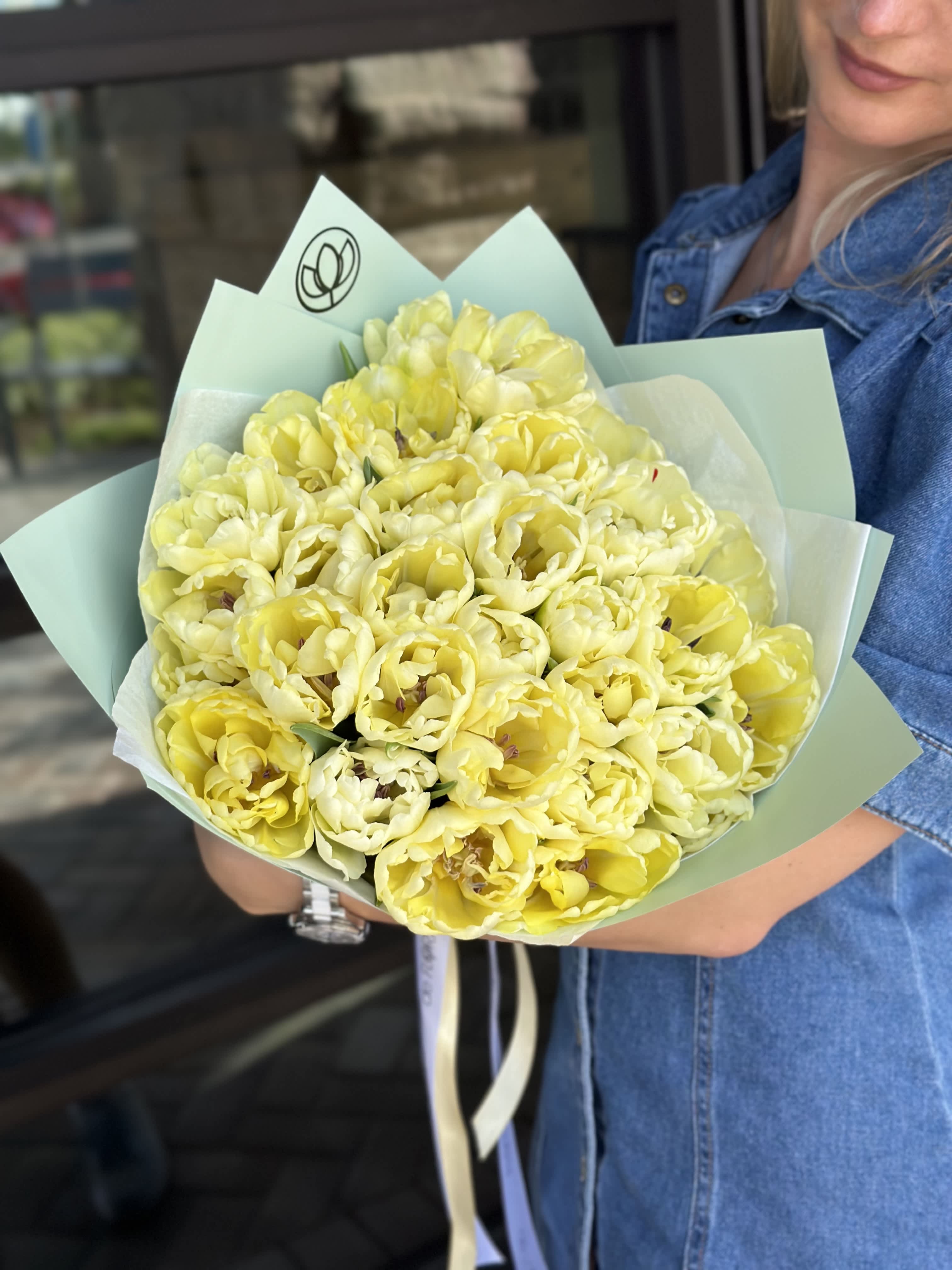 Bouquet of pale yellow tulips wrapped in mint paper