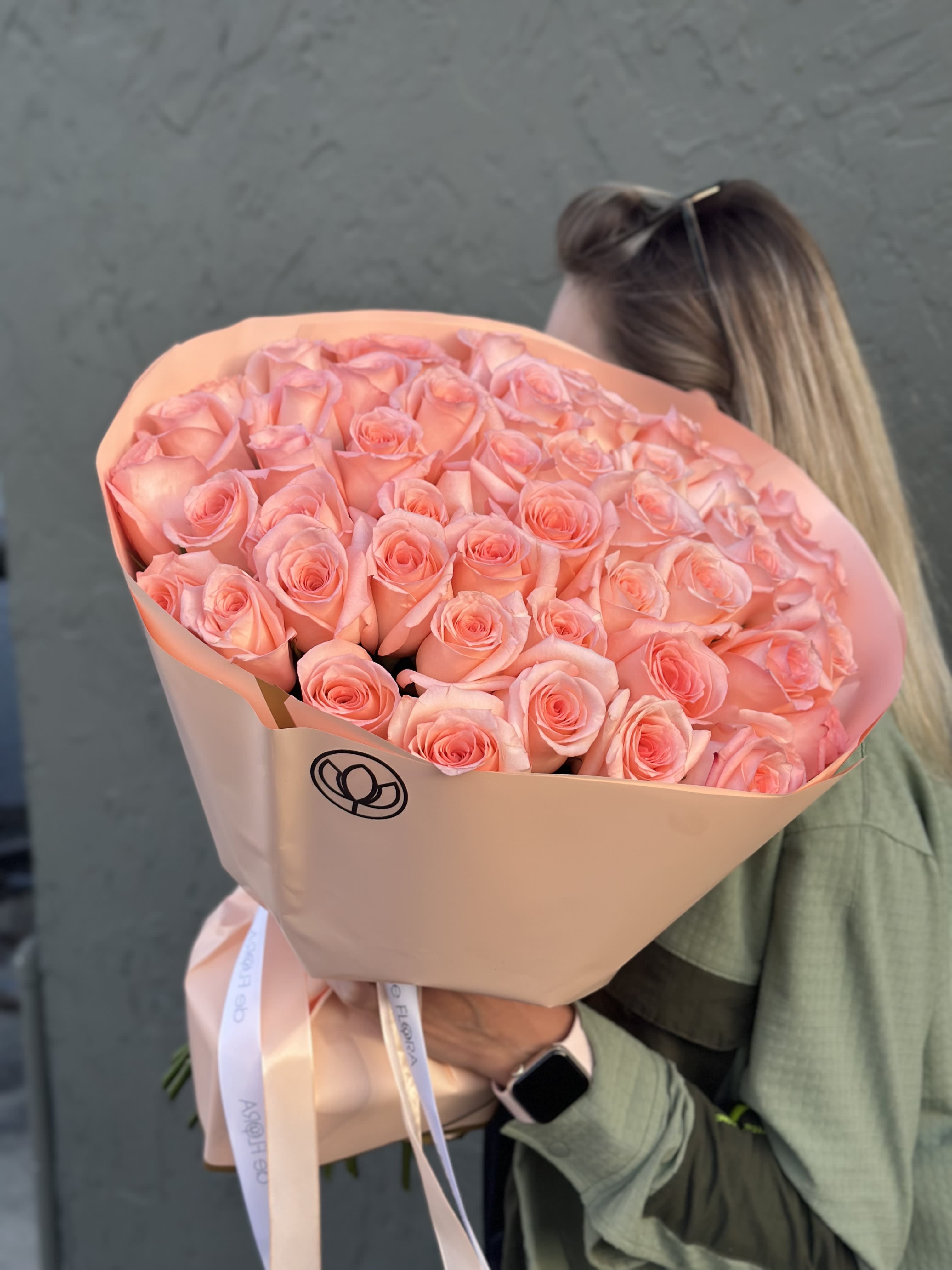 Large bouquet of peach-pink roses wrapped in blush paper