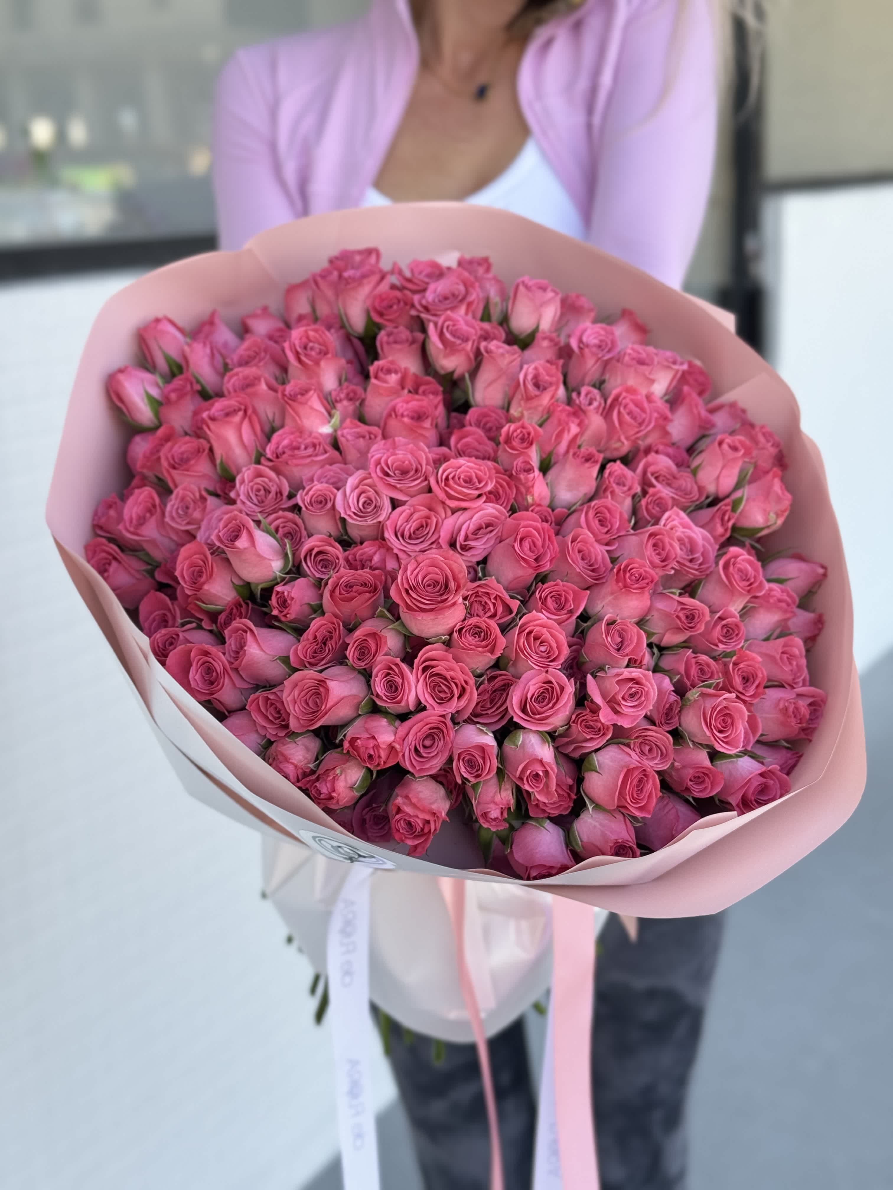 Large bouquet of pink roses wrapped in pale pink paper