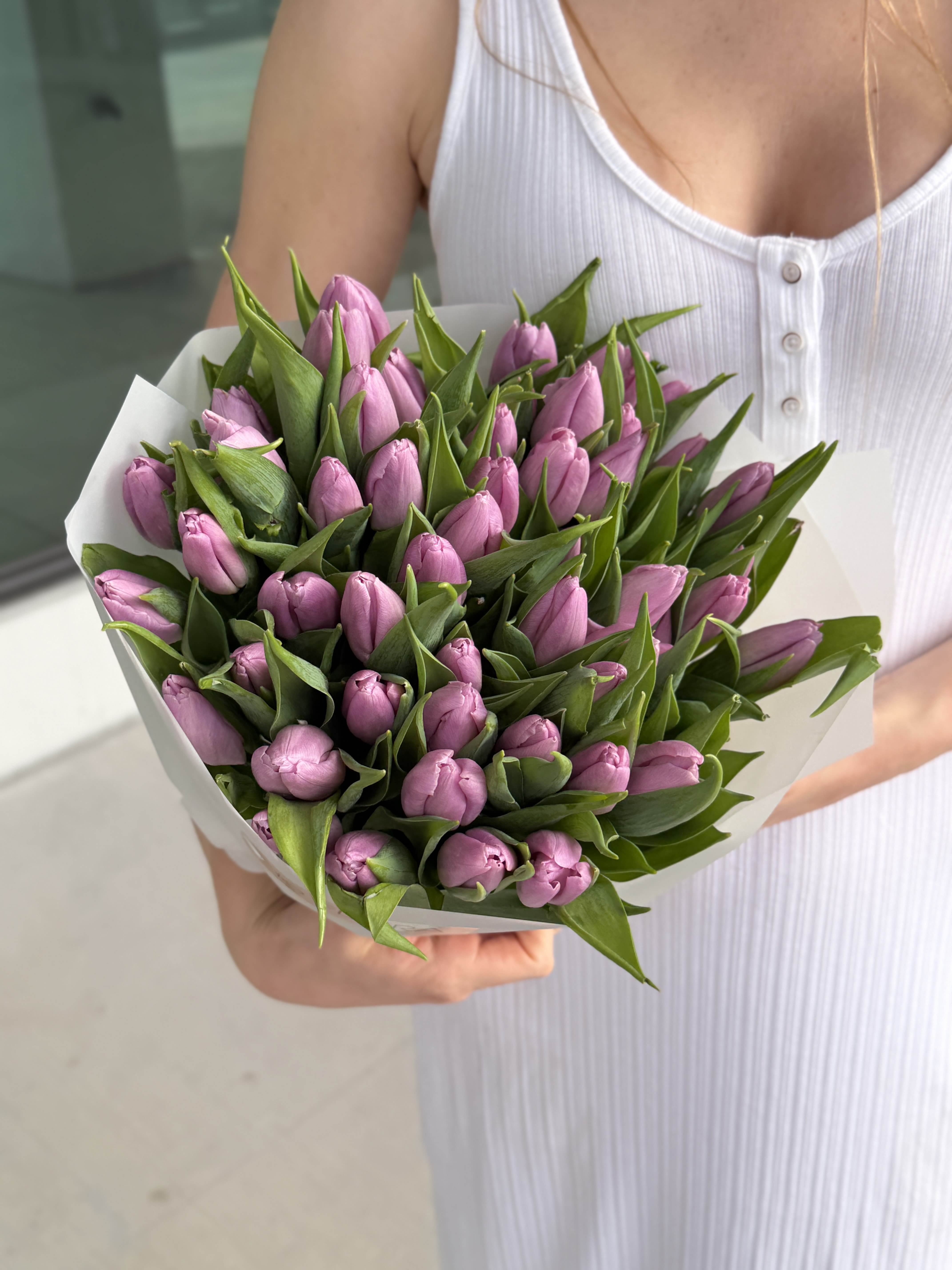 Bouquet of pink tulips wrapped in white paper