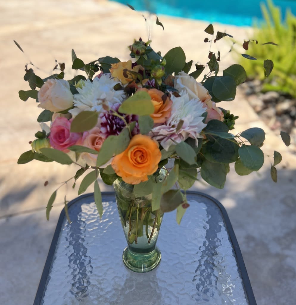 Mixed bouquet of roses and white blooms in a glass vase