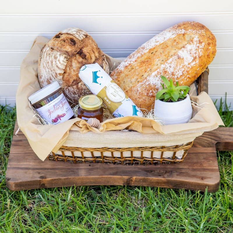 Gift basket with bread, jam, and a small potted succulent