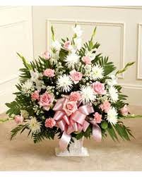 Pink and white floral spray with a pink ribbon on a stand