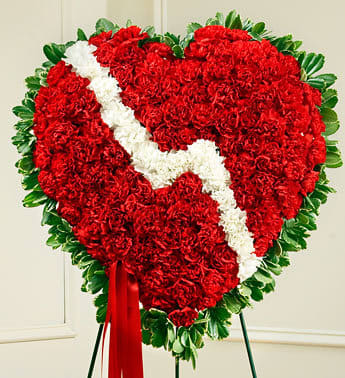 Heart-shaped red and white floral standing spray on an easel