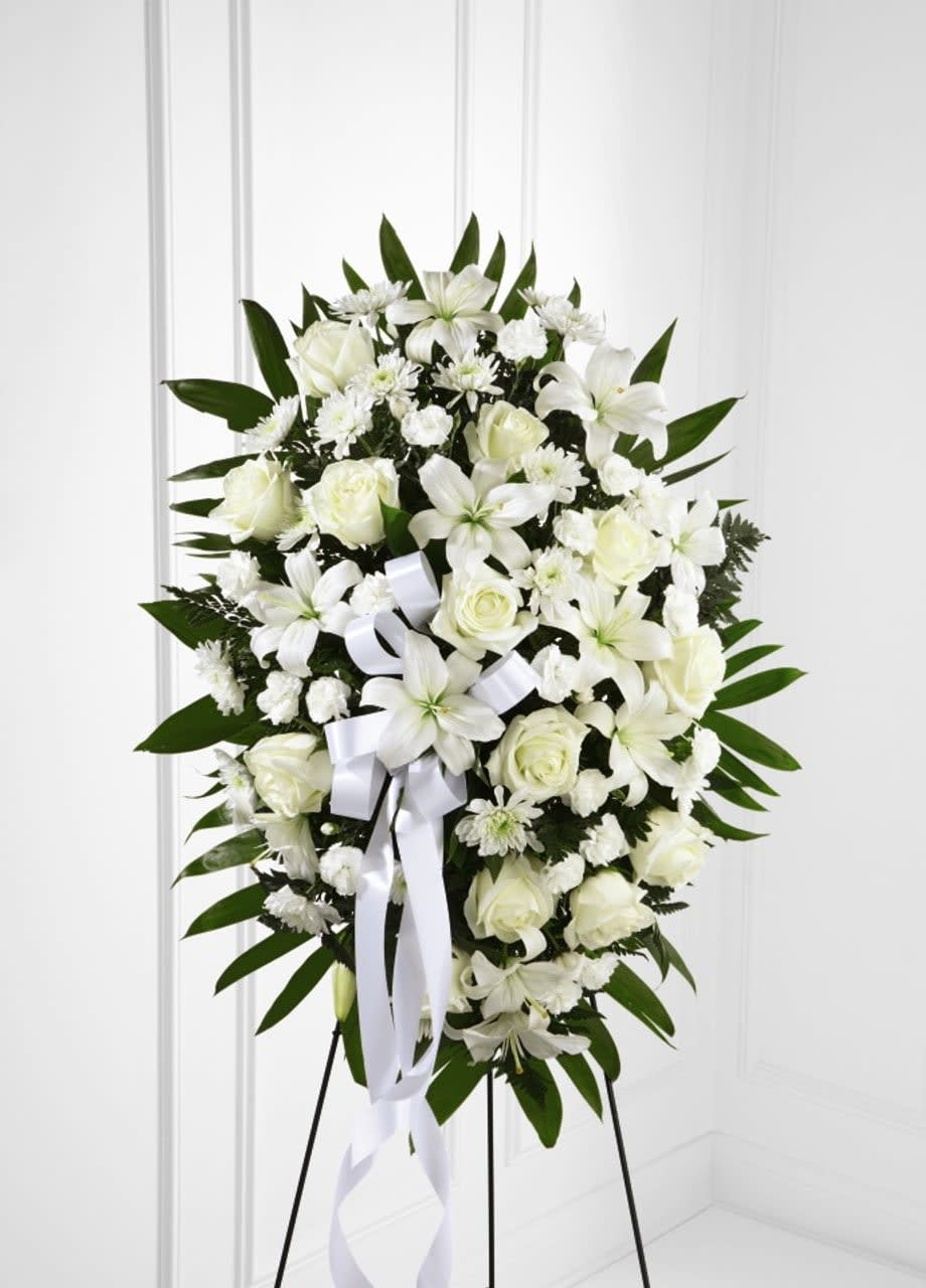Tribute Standing Spray - Remind your loved ones that you are thinking of them during this time of sensitivity with a display of sweet serenity. Our Exquisite Tribute™ Standing Spray is elegantly crafted with roses, lilies, mini carnations and accented with palm fronds. Each bloom in this grand arrangement shares your thoughtful condolences. - Details