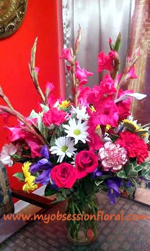 Bright mixed bouquet with pink roses and white daisies in a glass vase