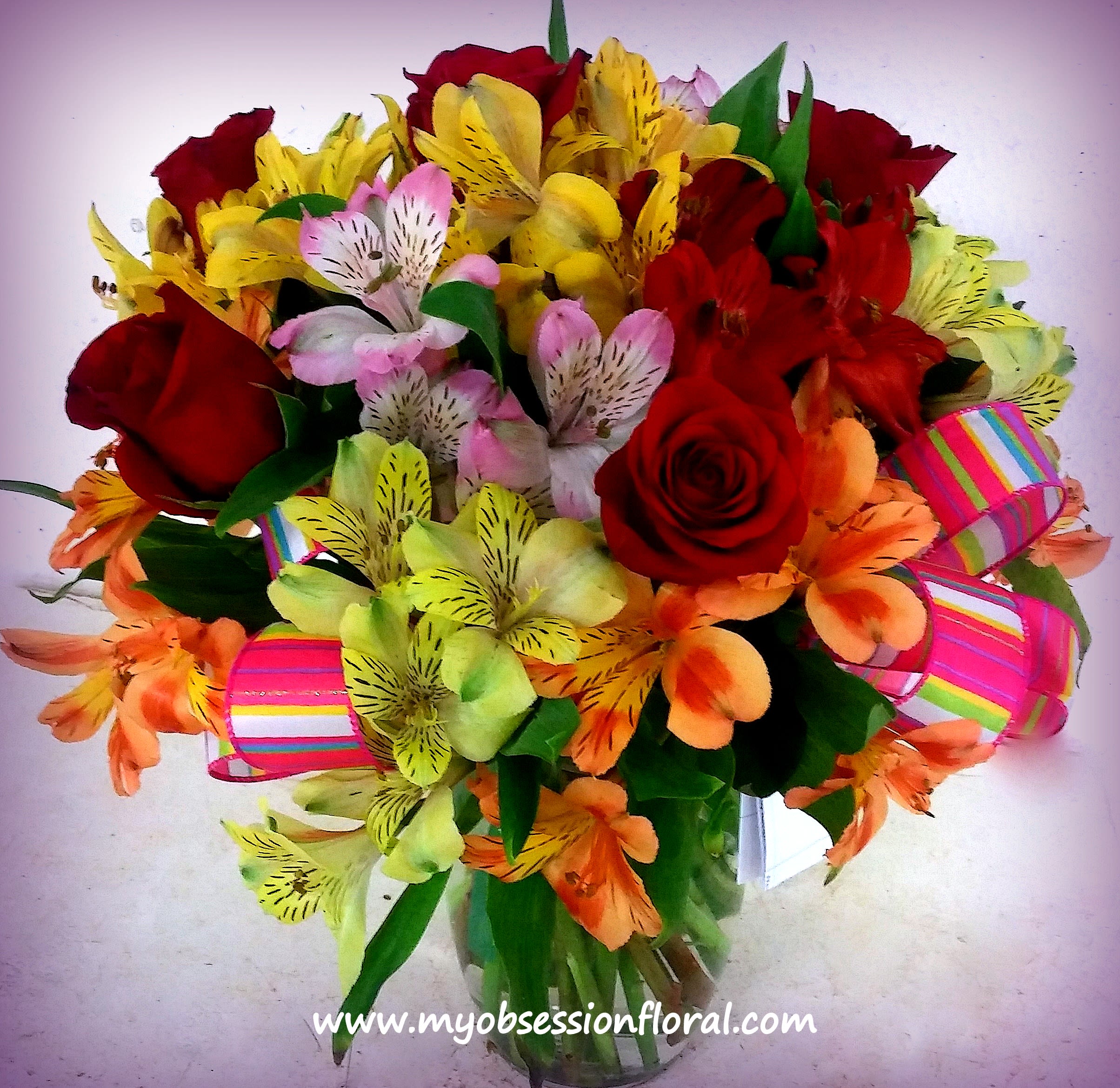 Bouquet of red roses and colorful alstroemeria with striped ribbon