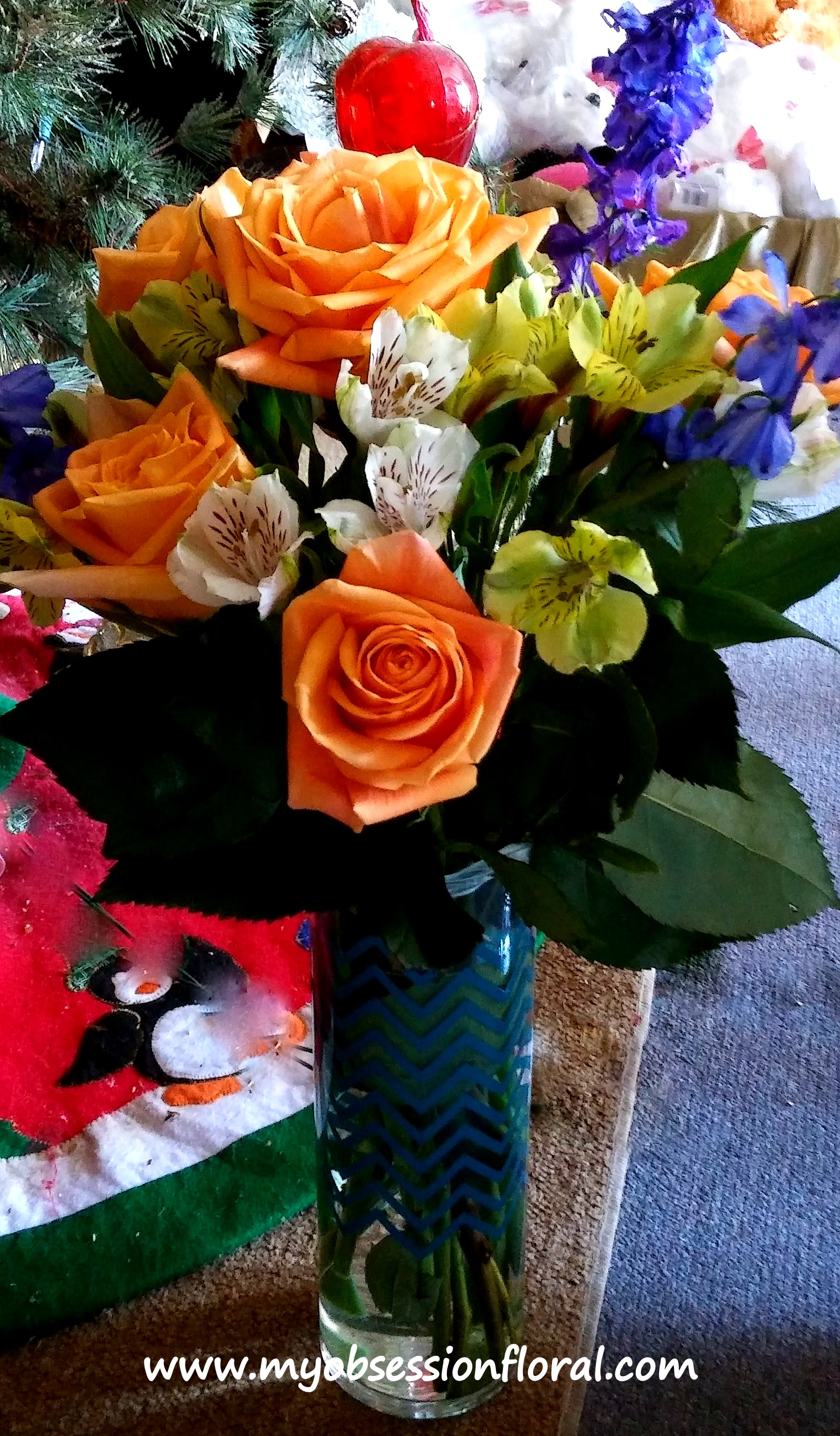Orange roses and mixed lilies in a glass vase