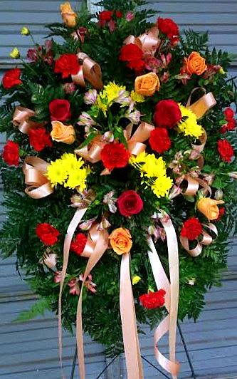 Standing floral spray with red and yellow roses and ribbon streamers
