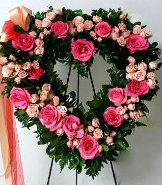 Heart-shaped floral wreath with pink roses and small pale pink blooms