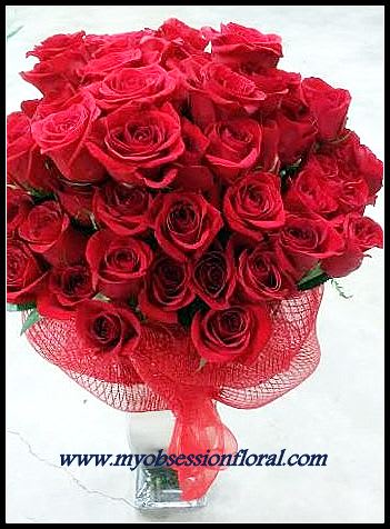 Bouquet of red roses wrapped in red mesh ribbon
