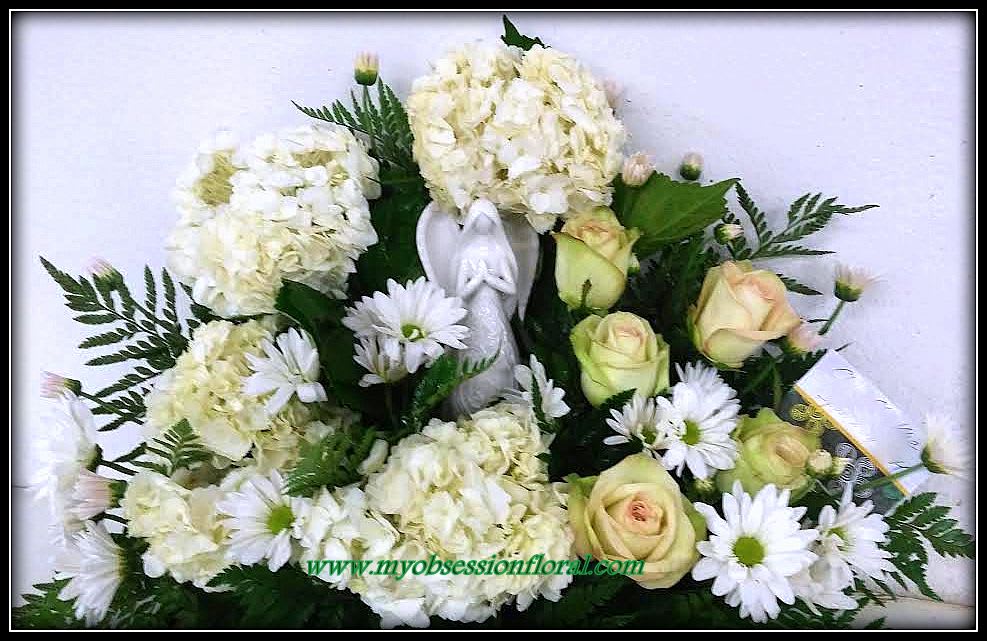 White hydrangeas and pale roses with daisies in a floral arrangement