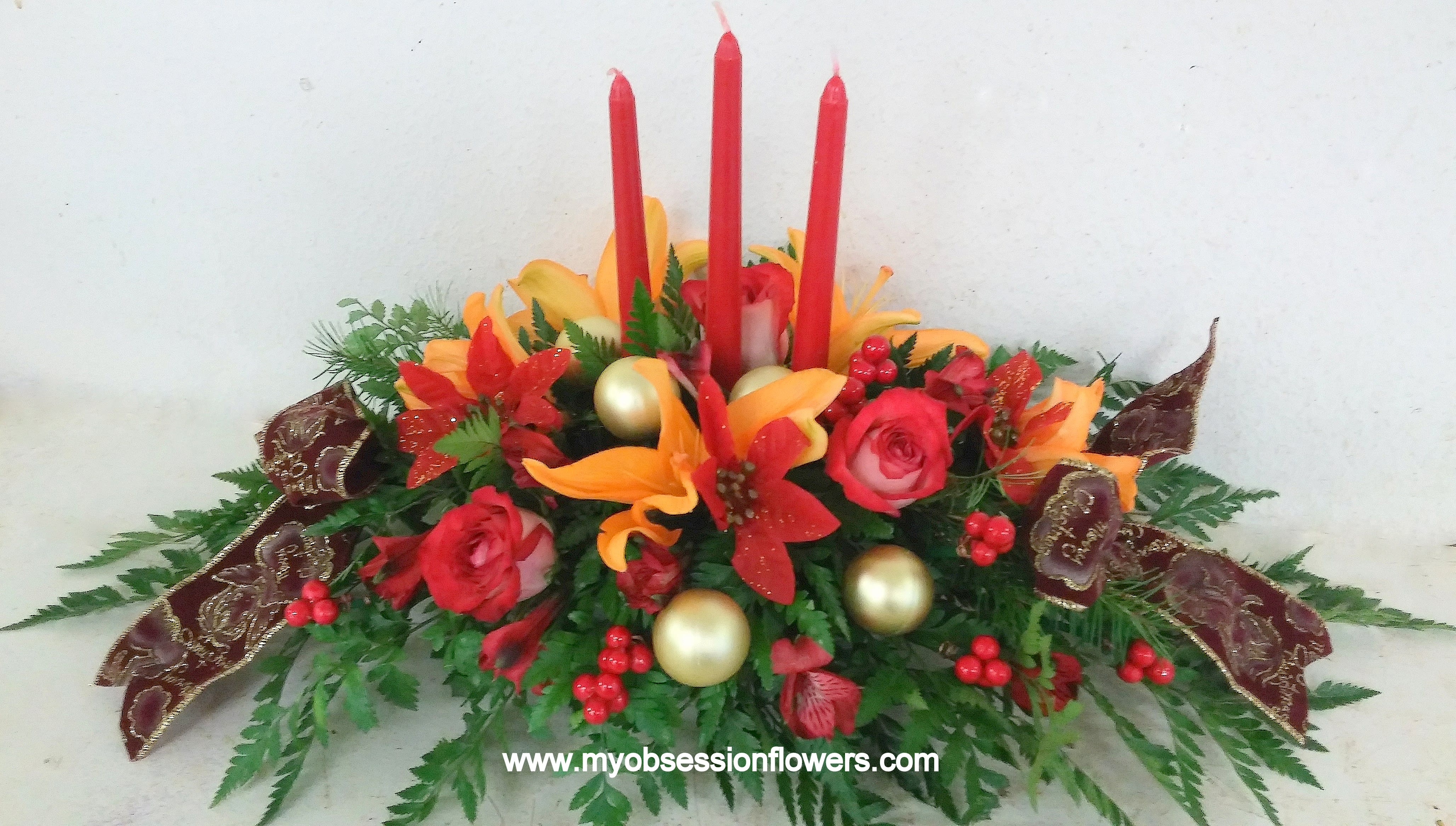 Red and orange floral centerpiece with tall red candles