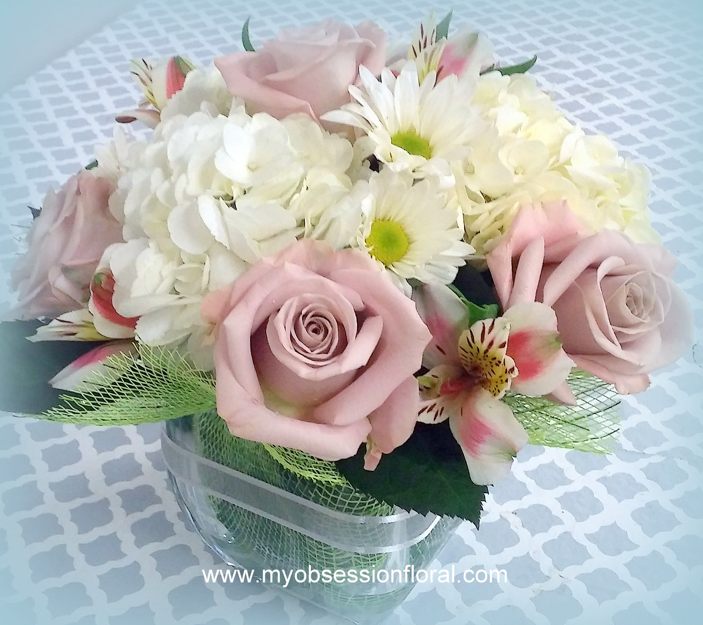 Pink roses and white daisies arranged in a clear vase