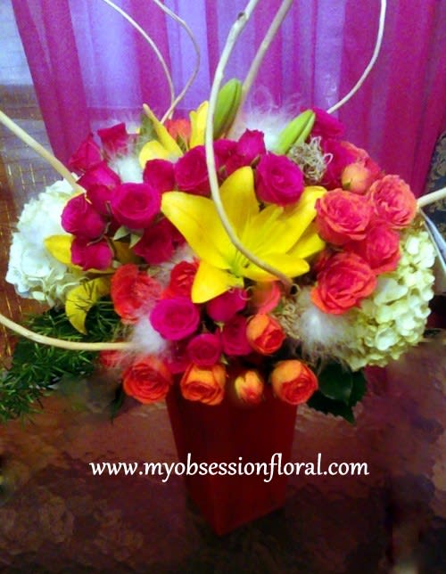 Bright mixed bouquet with yellow lilies and pink roses in a red vase