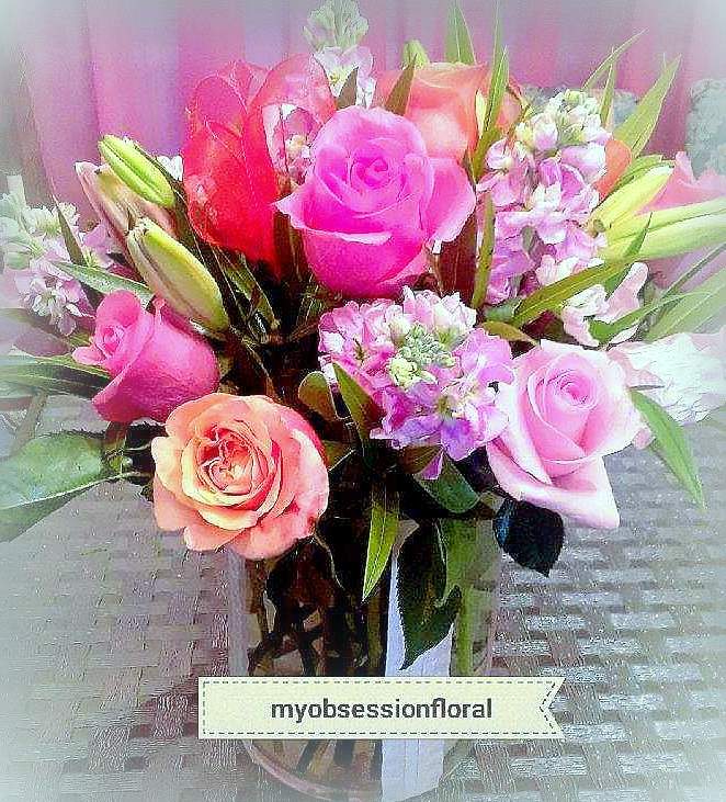 Bouquet of pink and peach roses with lilies in a glass vase