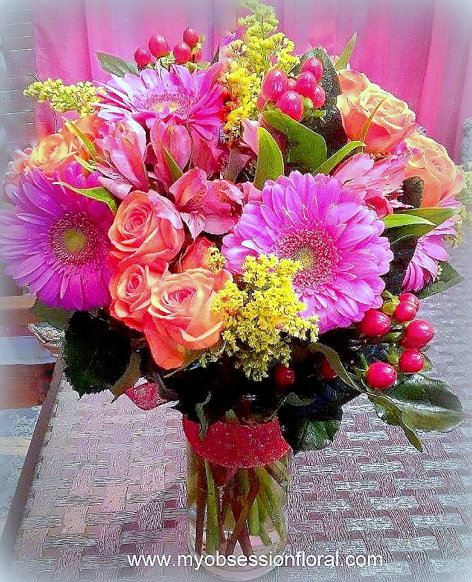 Bouquet of pink gerbera daisies and peach roses in a clear vase