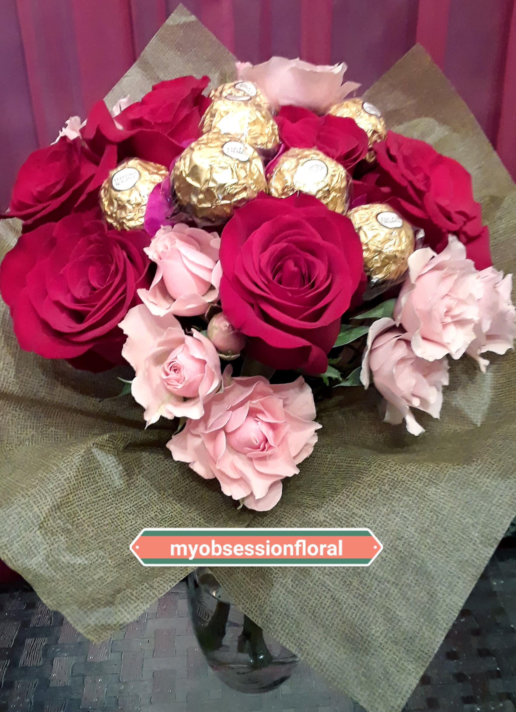 Bouquet of red and pink roses with gold-wrapped chocolates