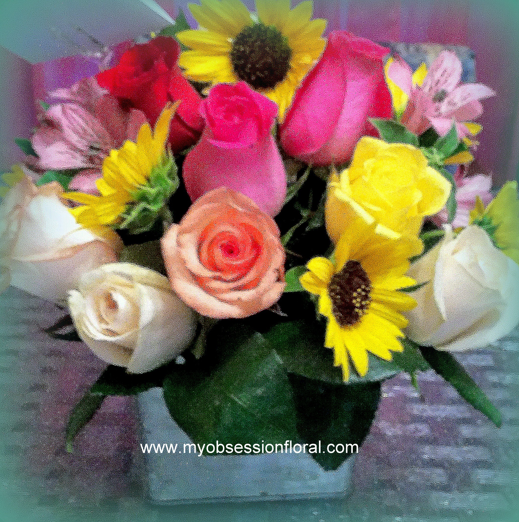 Mixed bouquet of roses and sunflowers in a clear vase