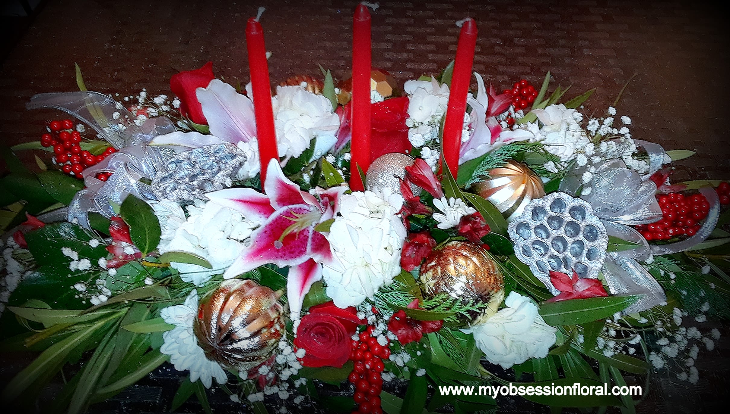 Red and white floral centerpiece with tall red candles