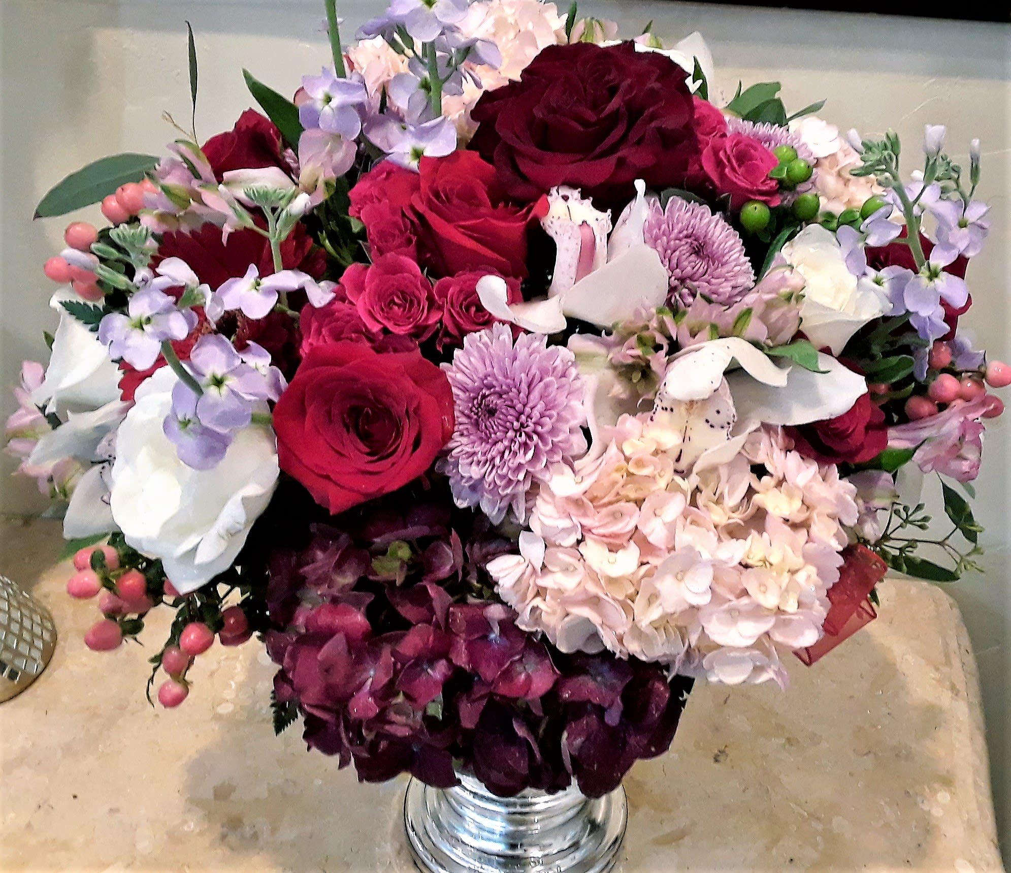 Bouquet of red roses, pink and white flowers in a silver vase