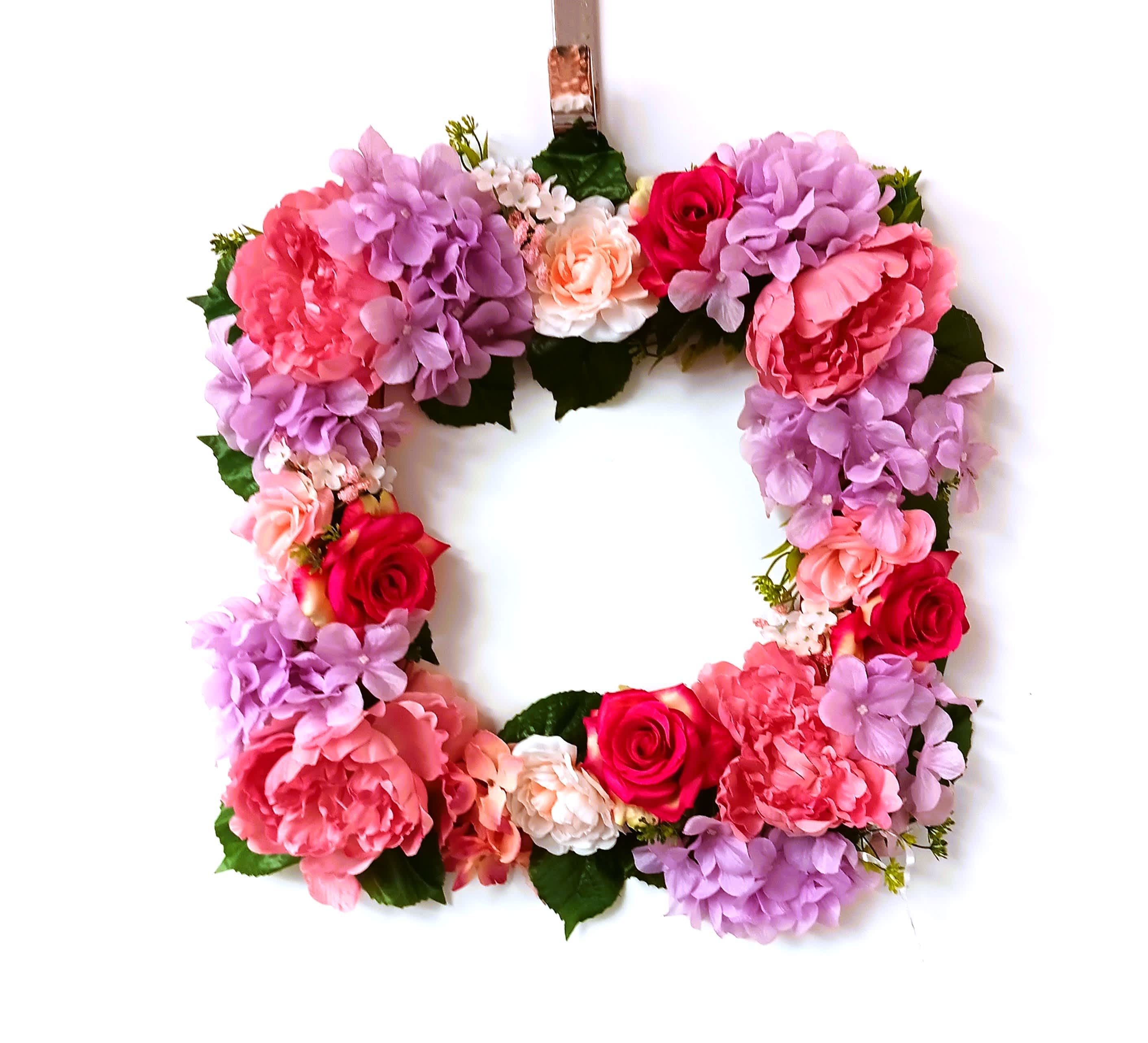 Floral wreath with pink, purple, and red blooms on a white background
