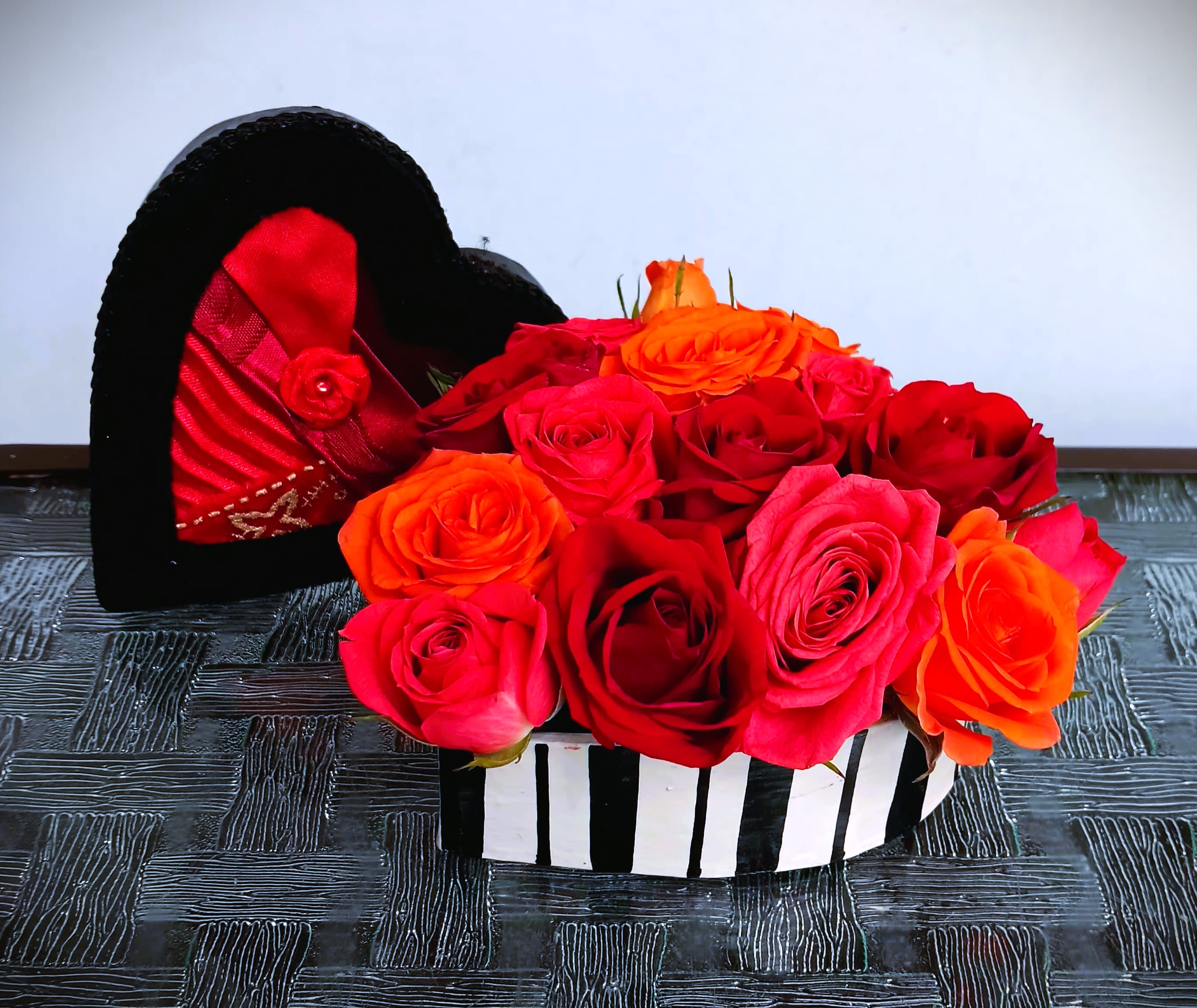Heart-shaped box filled with red, pink, and orange roses