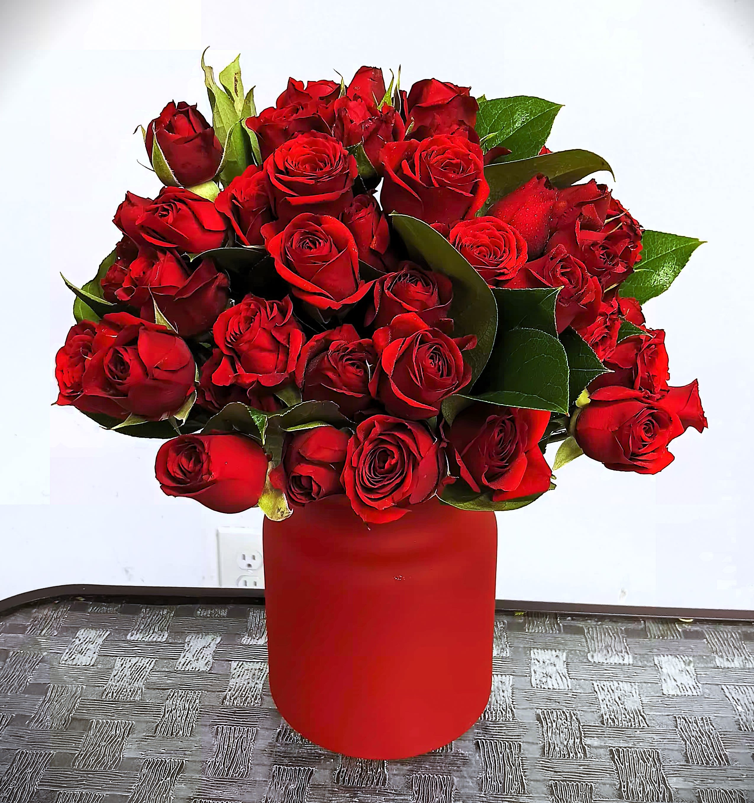 Red rose bouquet in a red cylindrical vase