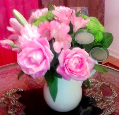 Pink floral bouquet in a white vase with green accents