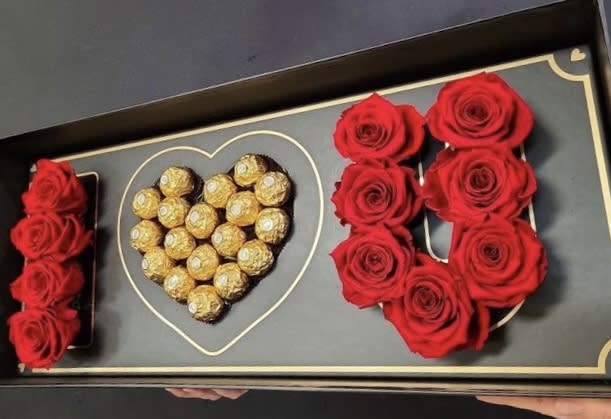 Boxed arrangement of red roses and Ferrero Rocher chocolates in heart shapes